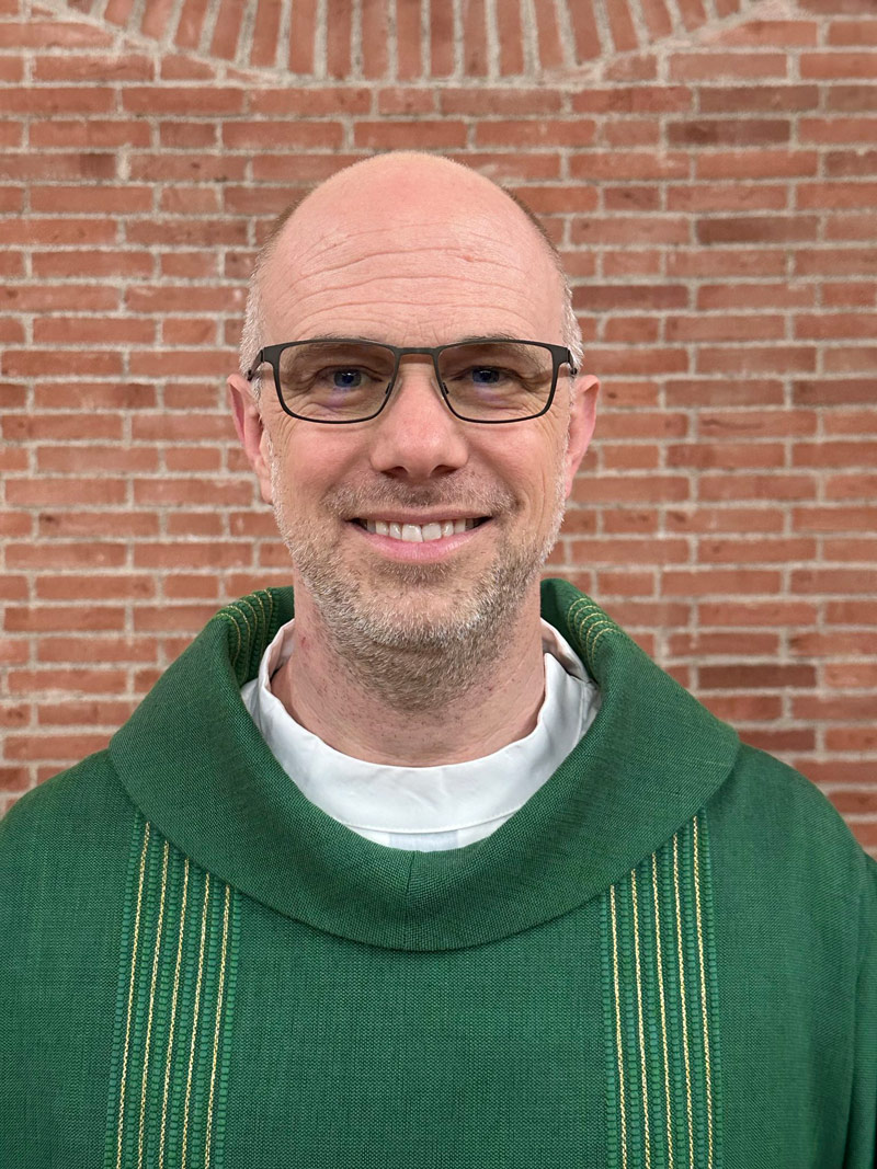 Portrait von Matthias Schmidt im grünen Pullover und mit Brille