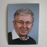 Foto J. Six Das farbige Foto zeigt J. Six. Mit Brille, graue, kurze Haare, weißem Hemd und dunkelen Pullover