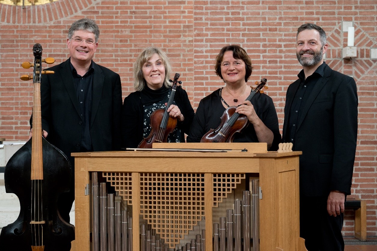 Farbiges Foto zeigt das Ensemble Bavarocco in der Kirche St. Ulrich. 4 Musiker mit ihren Instrumenten. Zwei Männer, einer davon der Kirchenmusiker M. Berthel und zwei Frauen.
